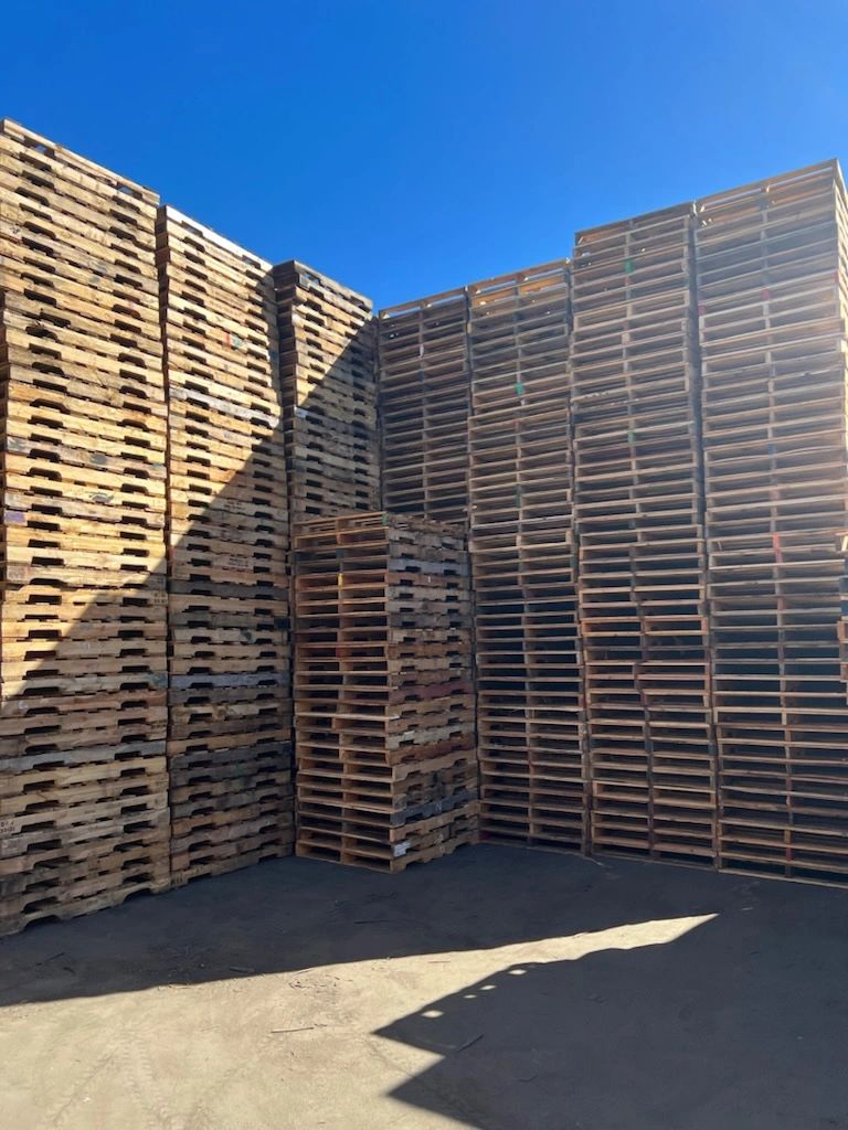 Stacked wooden pallets in a warehouse yard